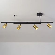 three lights are hanging from the ceiling in a room with white walls and flooring