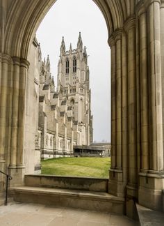 an archway leading into a large building with tall towers