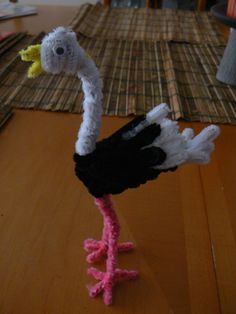 an ostrich made out of yarn sitting on top of a wooden table