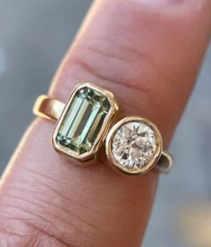 a close up of a person's hand with an engagement ring on their finger