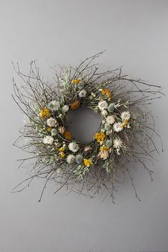 a dried wreath with yellow and white flowers