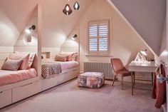 an attic bedroom with two twin beds and desk