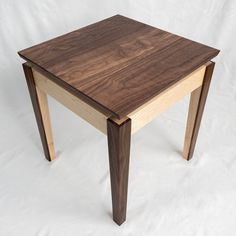 a wooden table sitting on top of a white sheet