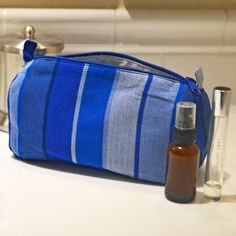 Pack your makeup or toiletries into our Stormy Blues striped multipurpose cosmetic bag, and toss it into your handbag, tote, or suitcase. Lined with white ripstop nylon, it will protect all the rest of your belongings from accidental spills. See the matching Toiletry Bag! Easy to access and easy to wash. Handwoven in 100% Cotton. White interior. Long pull zipper. 8”L x 3” D x 4.5” W Ethically made Blue Travel Cosmetic Bag With Removable Pouch, Blue Pouch Cosmetic Bag, Functional Blue Pouch Cosmetic Bag, Blue Cosmetic Bag For Everyday Use, Blue Travel Pouch Accessories, Blue Functional Cosmetic Bag, Blue Rectangular Zipper Travel Pouch, Blue Zipper Pouch Travel Accessories, Blue Zipper Pouch Travel Accessories For Everyday Use