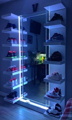 there are many shoes on the shelves in this room, all lit up with blue lights