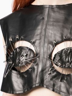 a woman wearing a black leather vest with metal rivets on the front and sides