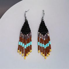 a pair of earrings with beads on them