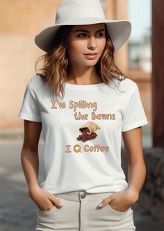 "Description: 👕 Are you looking for a wardrobe staple that perfectly encapsulates your love for coffee? Your search ends with our \"I'm spilling the beans; I love coffee\" t-shirt. Made from luxurious 100% airlume combed and ringspun cotton, this tee is more than just clothing; it's a statement of your unwavering passion for that daily cup of joy. The lightweight fabric ensures year-round comfort, while the stylish ribbed knit collars and shoulder taping provide a modern fit that complements any occasion. 👕 This funny coffee shirt with durable dual side seams and a retail fit doesn't just celebrate your love for java--it does so with unbeatable quality and timeless style. Available in various sizes, it's the perfect gift for the coffee connoisseur in your life, offering both comfort and Coffee Colored Crew Neck Top With Slogan, Coffee Color Short Sleeve Top With Slogan, Coffee Color Short Sleeve Top With Text Print, Coffee Colored Cotton Slogan Top, Coffee Color Crew Neck Top With Text Print, Coffee Colored Slogan Short Sleeve Top, Coffee Colored Short Sleeve Slogan Top, Coffee Colored Short Sleeve Shirt With Letter Print, Coffee Short Sleeve Top With Slogan