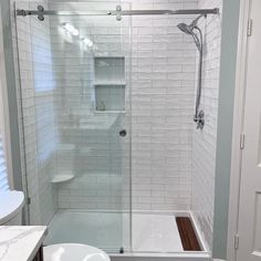 a walk in shower sitting next to a white sink