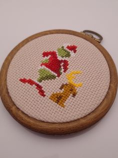 a cross stitch pattern on a wooden hoop