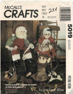 two santa claus dolls sitting next to each other in front of a wine bottle label