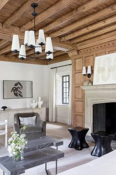 a living room with white furniture and wood paneled walls, along with a fireplace