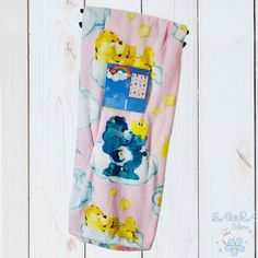 a towel hanging on the side of a wooden wall with rubber ducky ducks all over it