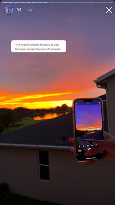 someone holding up their cell phone in front of a sunset