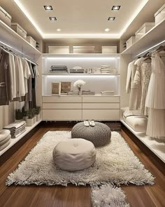 a walk in closet filled with lots of white furniture and clothes on hangers, along with a round ottoman