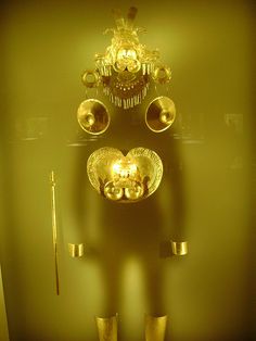 an artistic display with gold colored items on the wall