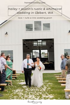 a bride and groom walking down the aisle at their wedding ceremony in front of a white barn