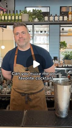 a man standing in front of a bar wearing an apron