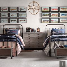 two beds in a room with pictures on the wall above them and below them is a dresser