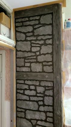 a door that is made out of some kind of stone wall in a house under construction