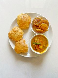 a white plate topped with three different types of food on top of a white table