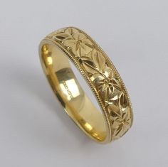 a gold wedding ring with an intricate design