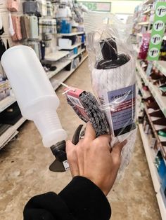 a person is holding a spray bottle in a store