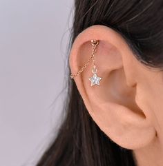 a woman's ear with a star charm on it