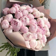 a person holding a bouquet of pink flowers