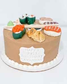 a birthday cake decorated with sushi and chopsticks