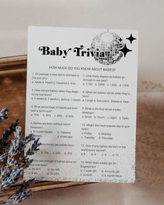 a baby trivia sitting on top of a wooden box next to lavender sprigs