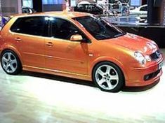 an orange car on display in a showroom