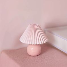 a pink lamp sitting on top of a bed