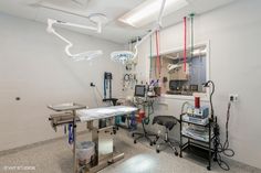 a hospital room with medical equipment and lights hanging from the ceiling in front of a mirror