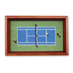 a cross stitch picture of a tennis court with two racquets on it