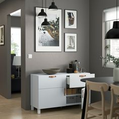 a dining room with grey walls and pictures on the wall