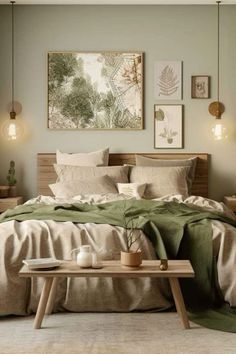 a bed with green sheets and pillows on top of it in a room filled with pictures