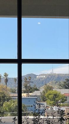 the view from inside a window shows mountains and palm trees