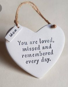 a white ceramic heart shaped ornament with the words you are loved, missed and remembranced every day