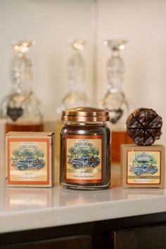 a jar of honey sitting on top of a counter next to two boxes with chocolate candies