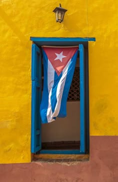 an image of a flag that is hanging out the side of a building in cuba