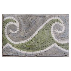 a green and white tile design on the side of a doormat that is made out of bricks