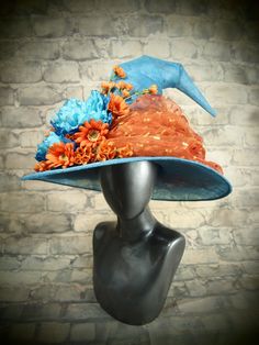 a mannequin head wearing an orange and blue hat with flowers on the brim