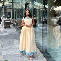 a woman standing in front of a glass wall with her hands on her hips and looking at the camera