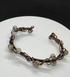 Wire Wrapped Copper Bracelet with Copper Swirls and Glass Bead Accents.Approximately 6" long - adjustable to the wrist. This bracelet has been antiqued, polished and sealed. Sealed with Protectaclear. ProtectaClear is a clear, protective coating that is tough enough to protect jewelry and is safe for wear against skin. ProtectaClear is practically invisible once applied and will seal and protect jewelry from tarnish, oxidation, and corrosion. Glass Bead Bracelet, Organic Design, Glass Beaded Bracelets, Copper Bracelet, Bead Bracelet, Glass Bead, Copper Wire, Colored Glass, Handcrafted Jewelry