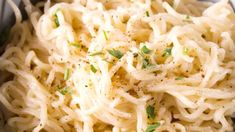 a bowl filled with pasta and topped with parsley