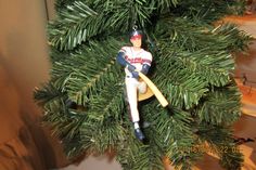 a baseball ornament is hanging on a christmas tree in the shape of a man