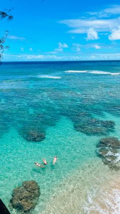 two people are swimming in the clear blue water