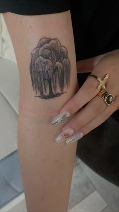 a woman's leg with an elephant tattoo on her left arm and two rings