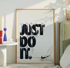 a black and white poster with the words just do it written in bold font, next to a bed